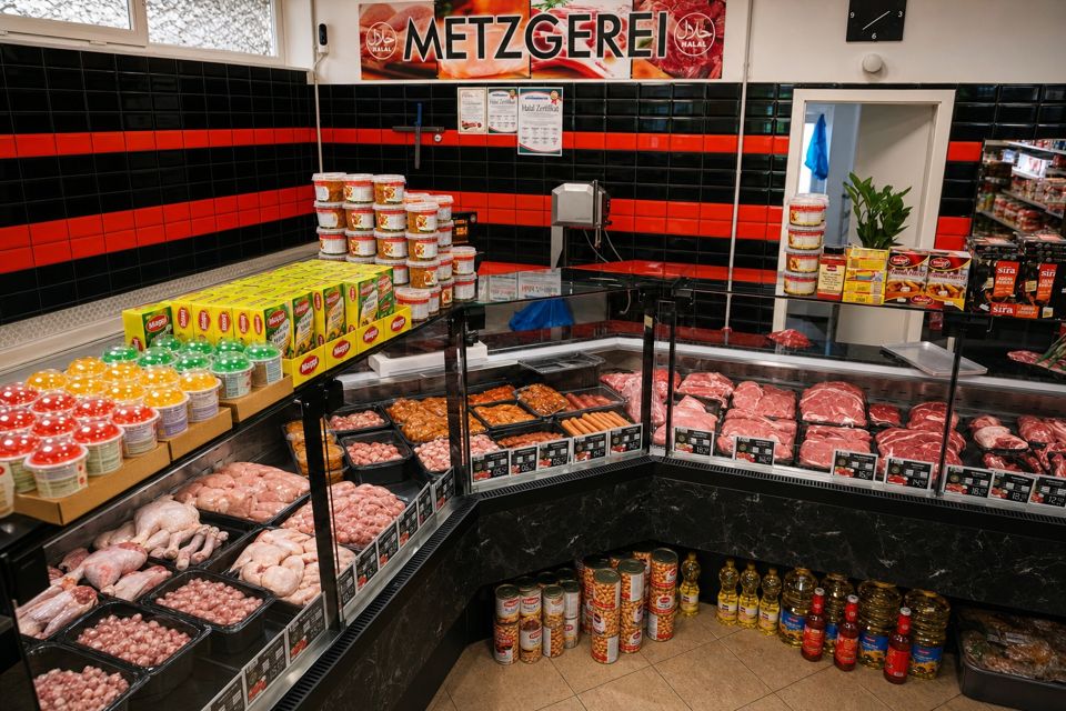 Die Fleischtheke im Azra Markt mit dem roten Schild Metzgerei über der Theke